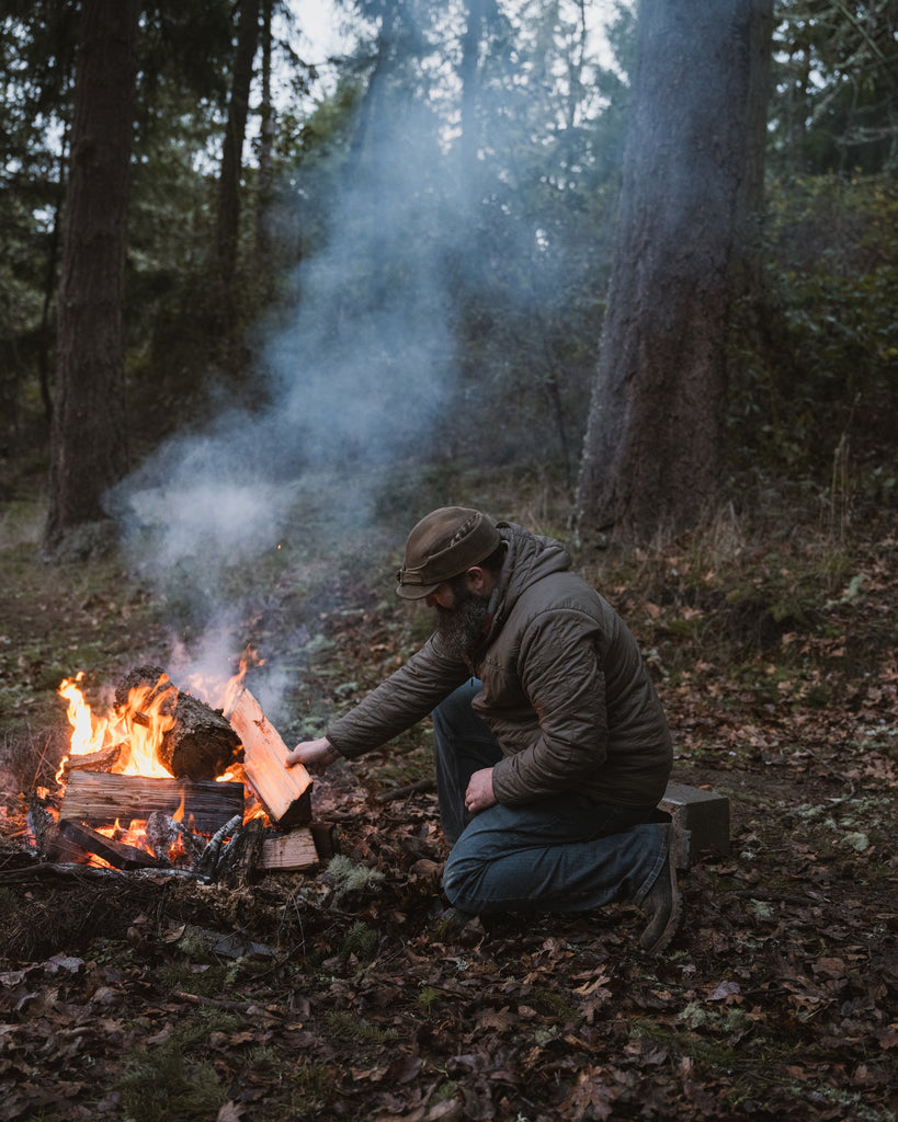 man building fire in woods