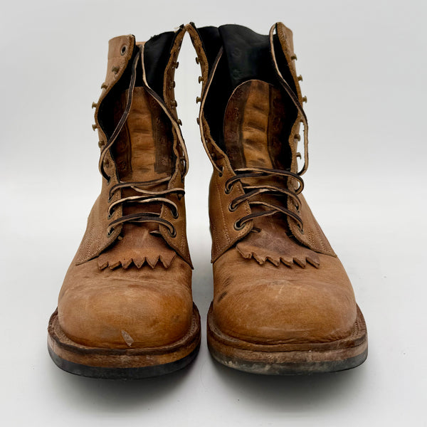 Pair of worn brown leather boots on a white background