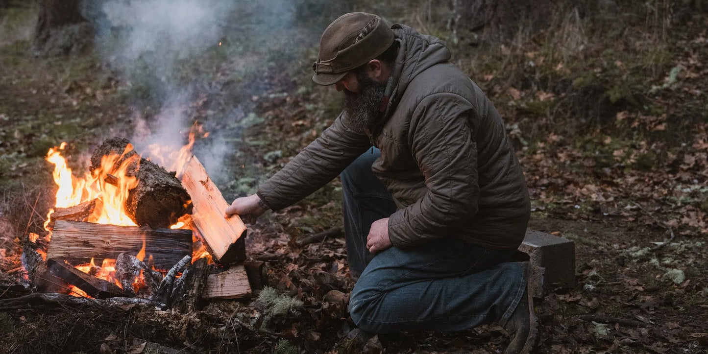 man building fire in woods