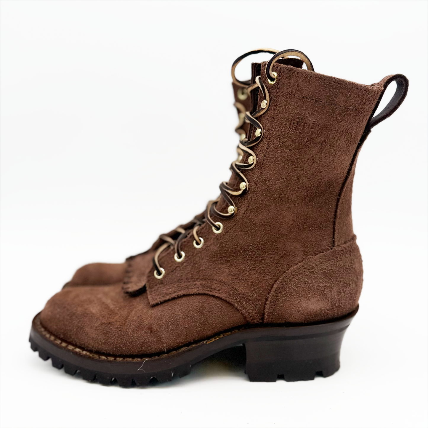 Brown suede boot with gold laces on a white background