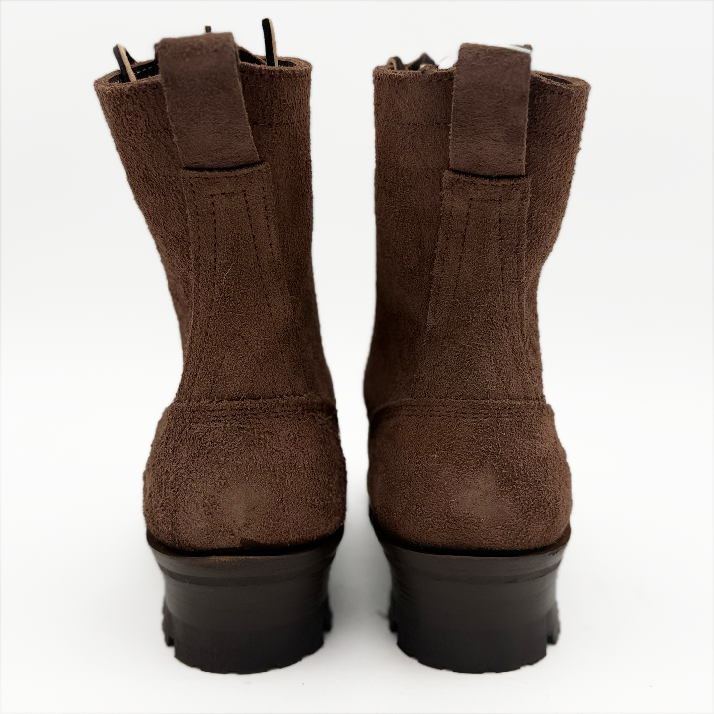 Pair of brown suede boots with pull tabs on a white background