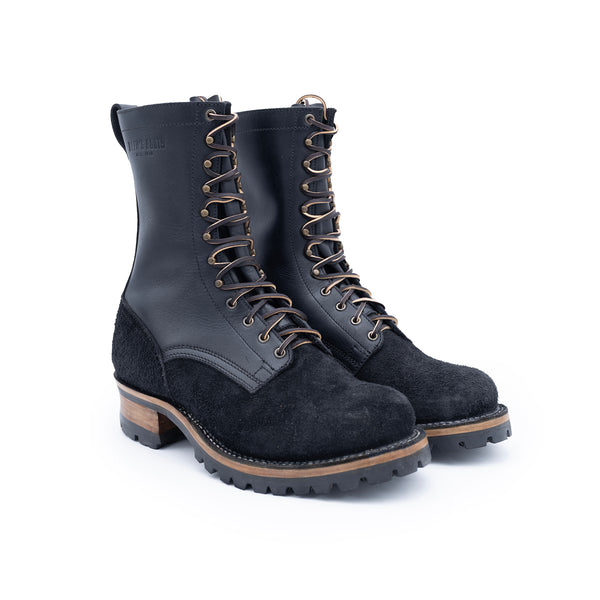 Pair of black leather and suede boots with brown soles on a white background