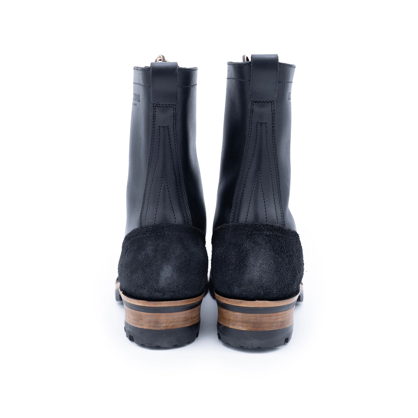 Pair of black rubber rain boots with suede soles on a white background