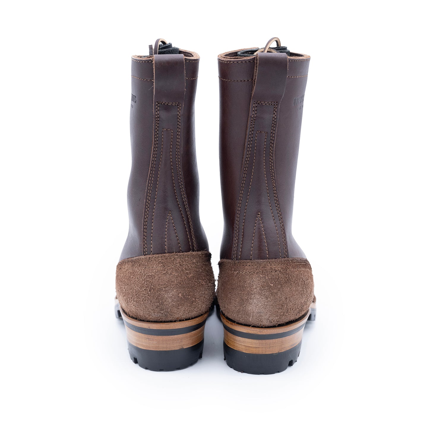 Pair of brown rubber boots with suede soles on a white background