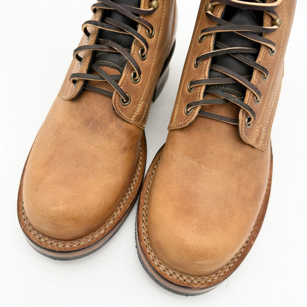 Pair of brown leather boots with black soles on a white background