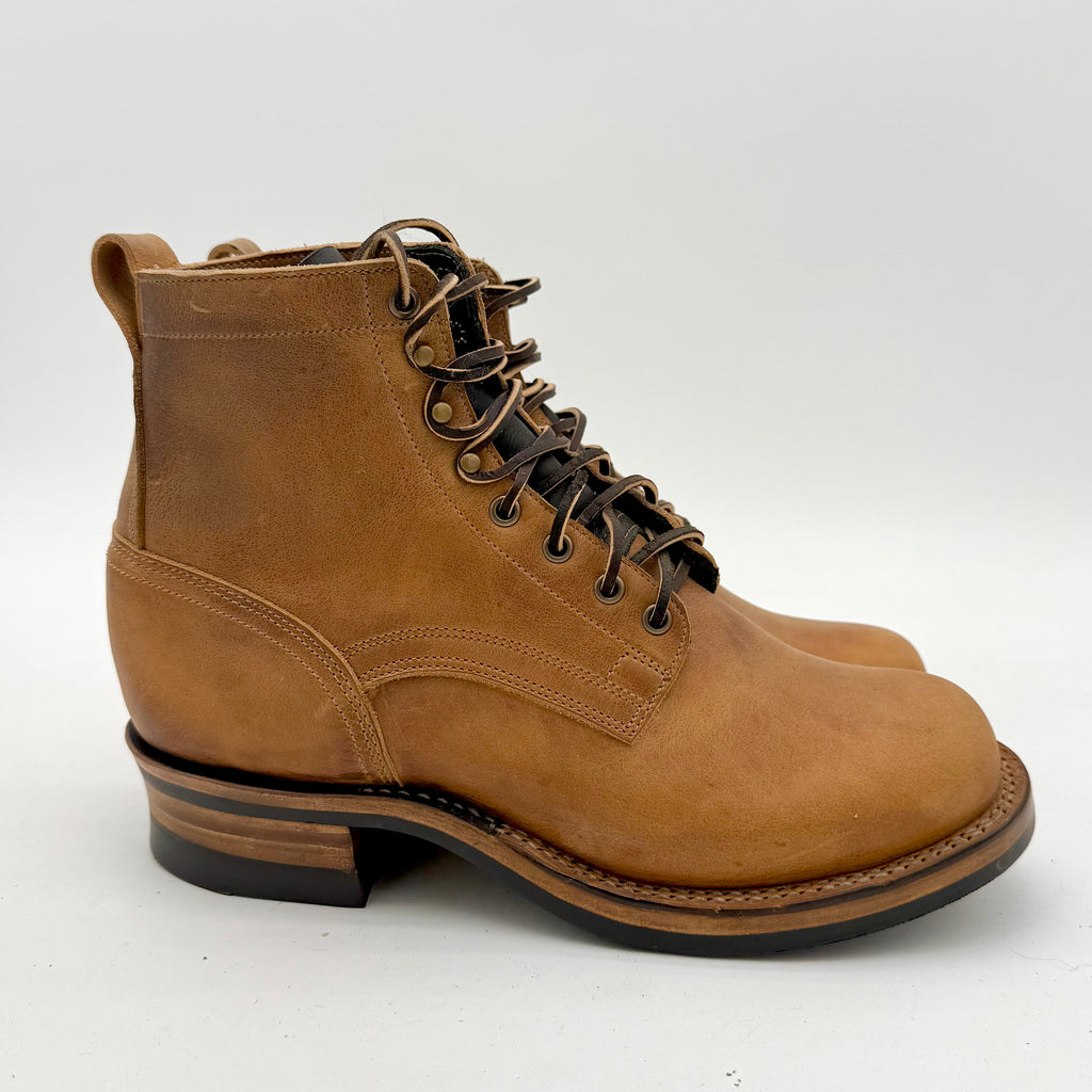 Brown leather boot with black sole on a white background