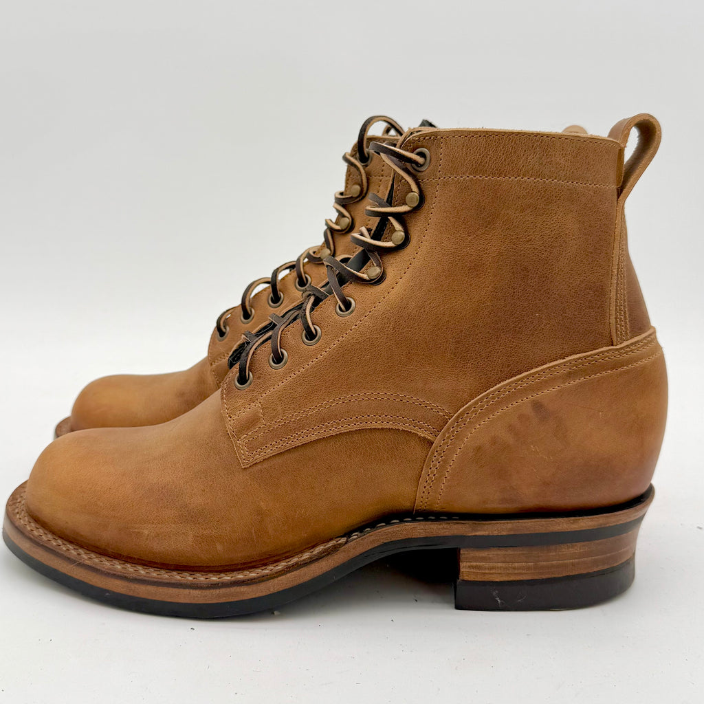 Brown leather boots with black soles on a white background