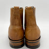 Pair of brown leather boots with black soles on a white background