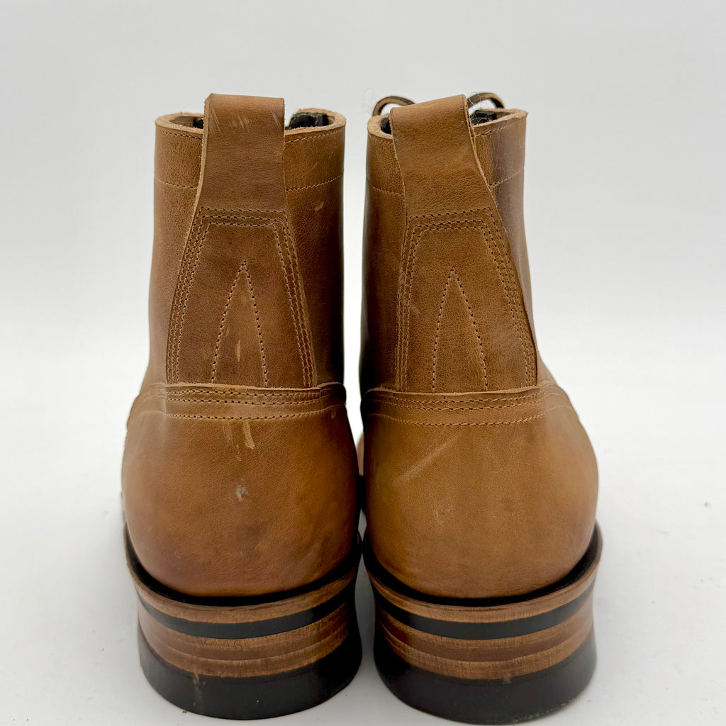 Pair of brown leather boots with black soles on a white background