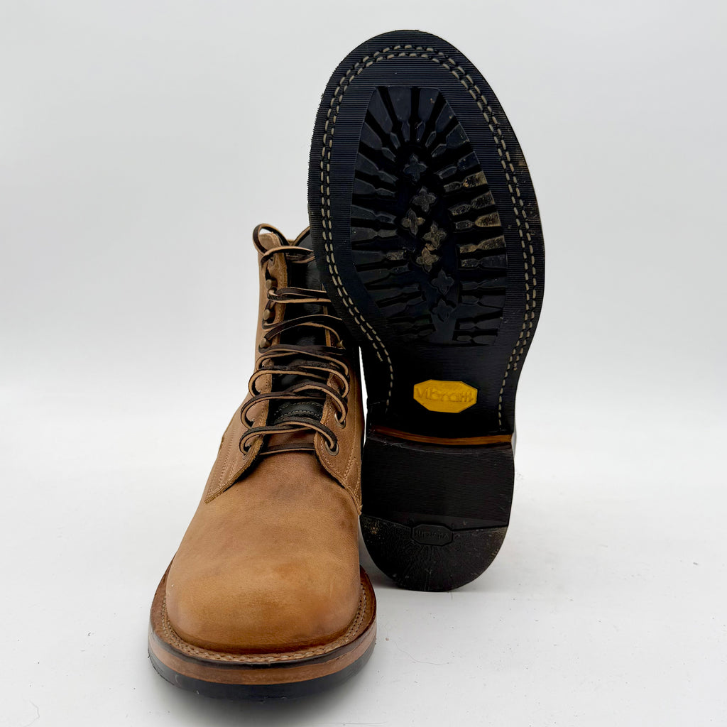Brown leather boot with black sole on a white background
