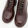 Pair of brown leather boots with laces on a white background