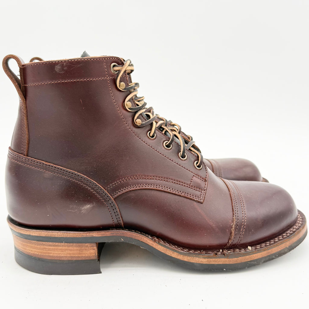 Brown leather boot with gold laces on a white background