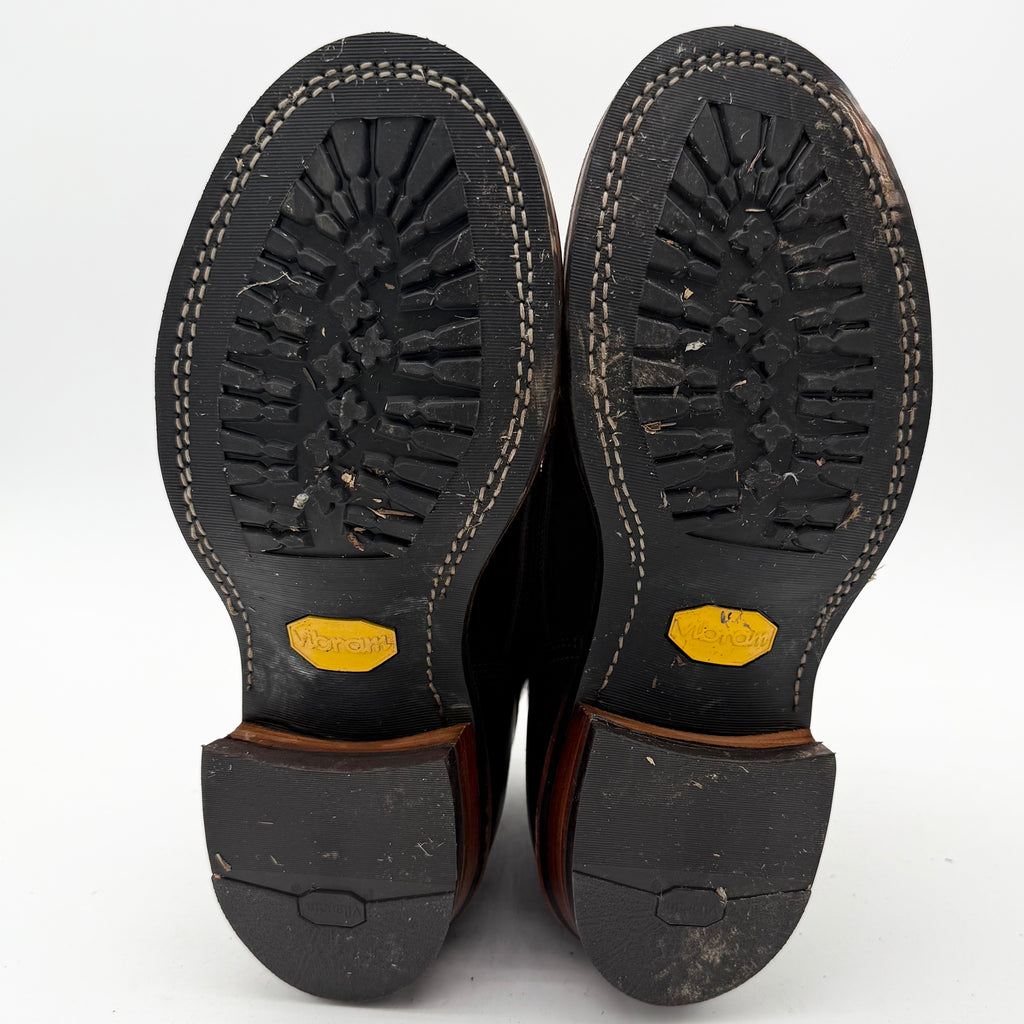 Close-up of black boot soles with VIBRAM brand logo on a white background