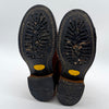 Black worn-out shoes with yellow accents on a white background