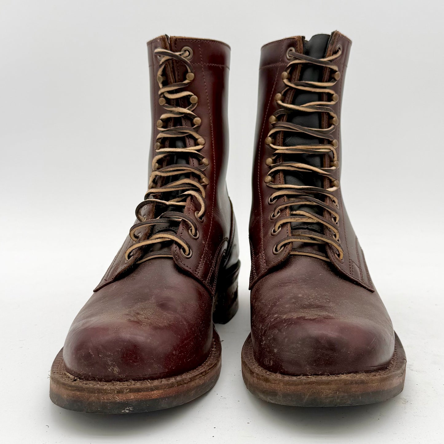 Pair of brown leather boots with laces on a white background