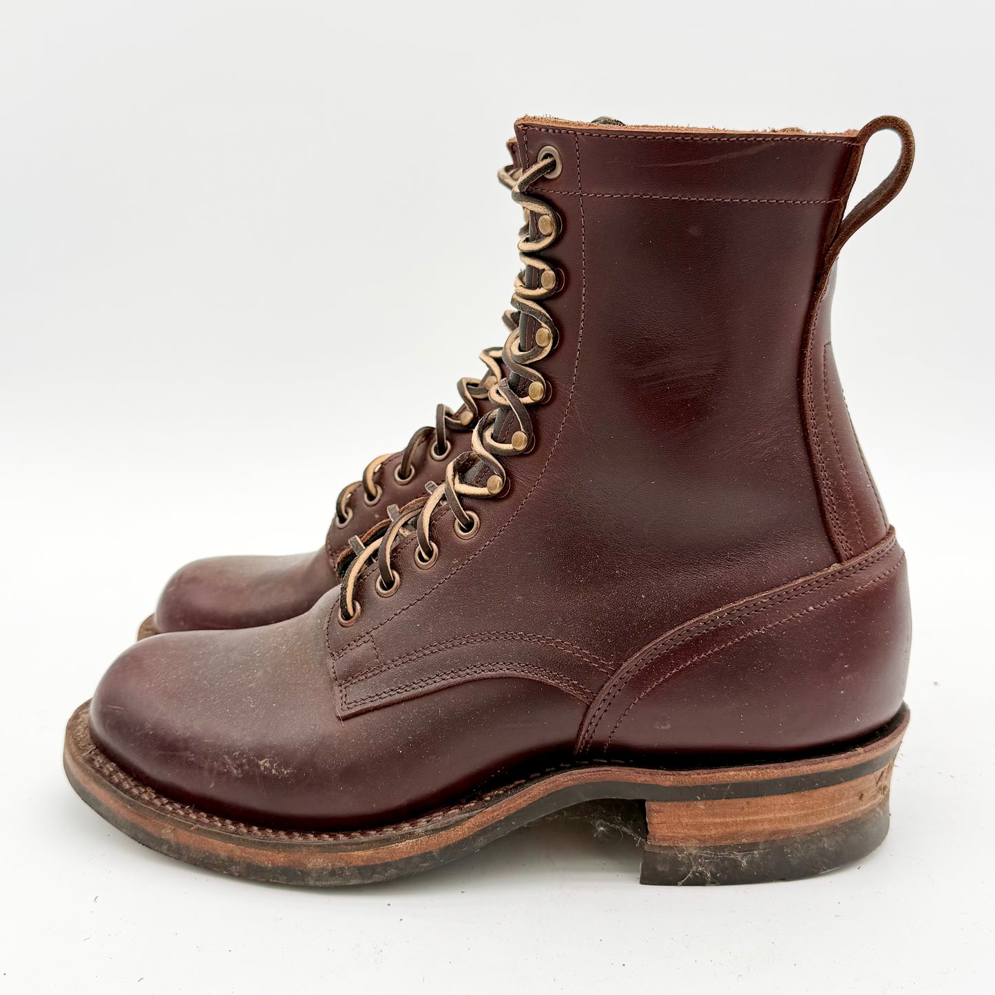 Brown leather boots with gold laces on a white background