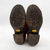Brown leather shoes with worn soles on a white background