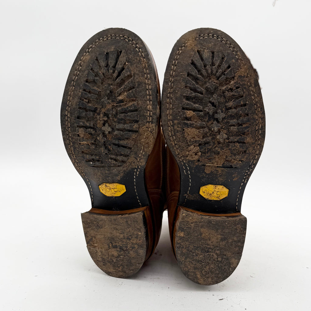 Brown leather shoes with worn soles on a white background