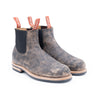 Pair of distressed brown Chelsea boots on a white background