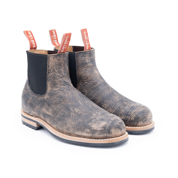 Pair of distressed brown Chelsea boots on a white background
