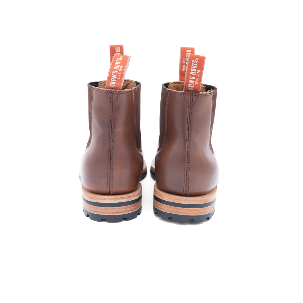 Pair of brown leather slip on chelsea boots with visible brand name on a white background
