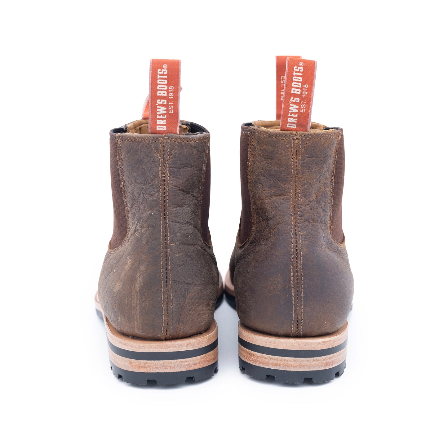Pair of brown leather boots with visible brand labels on a white background