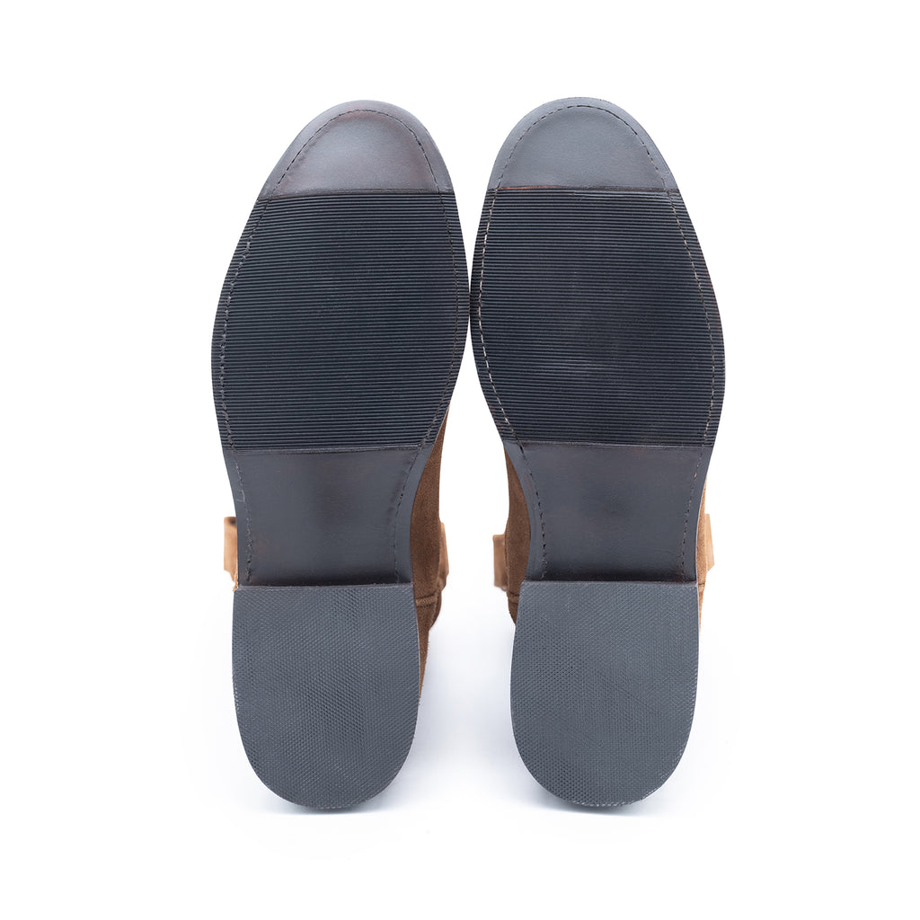 Pair of brown shoes with black soles on a white background