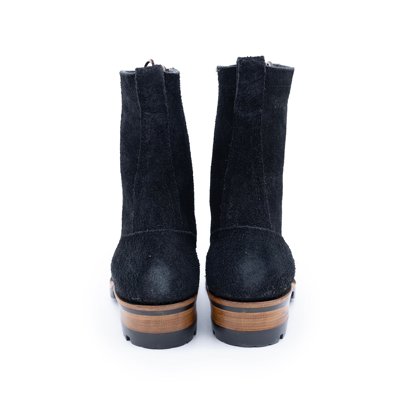 Pair of black suede boots with brown soles on a white background