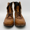 Pair of worn brown leather boots on a white background