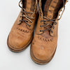 Pair of worn brown leather boots on a white background